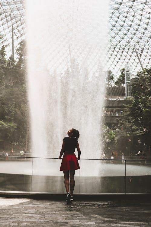 Woman Standing Under a Man-made Flowing Water Fall