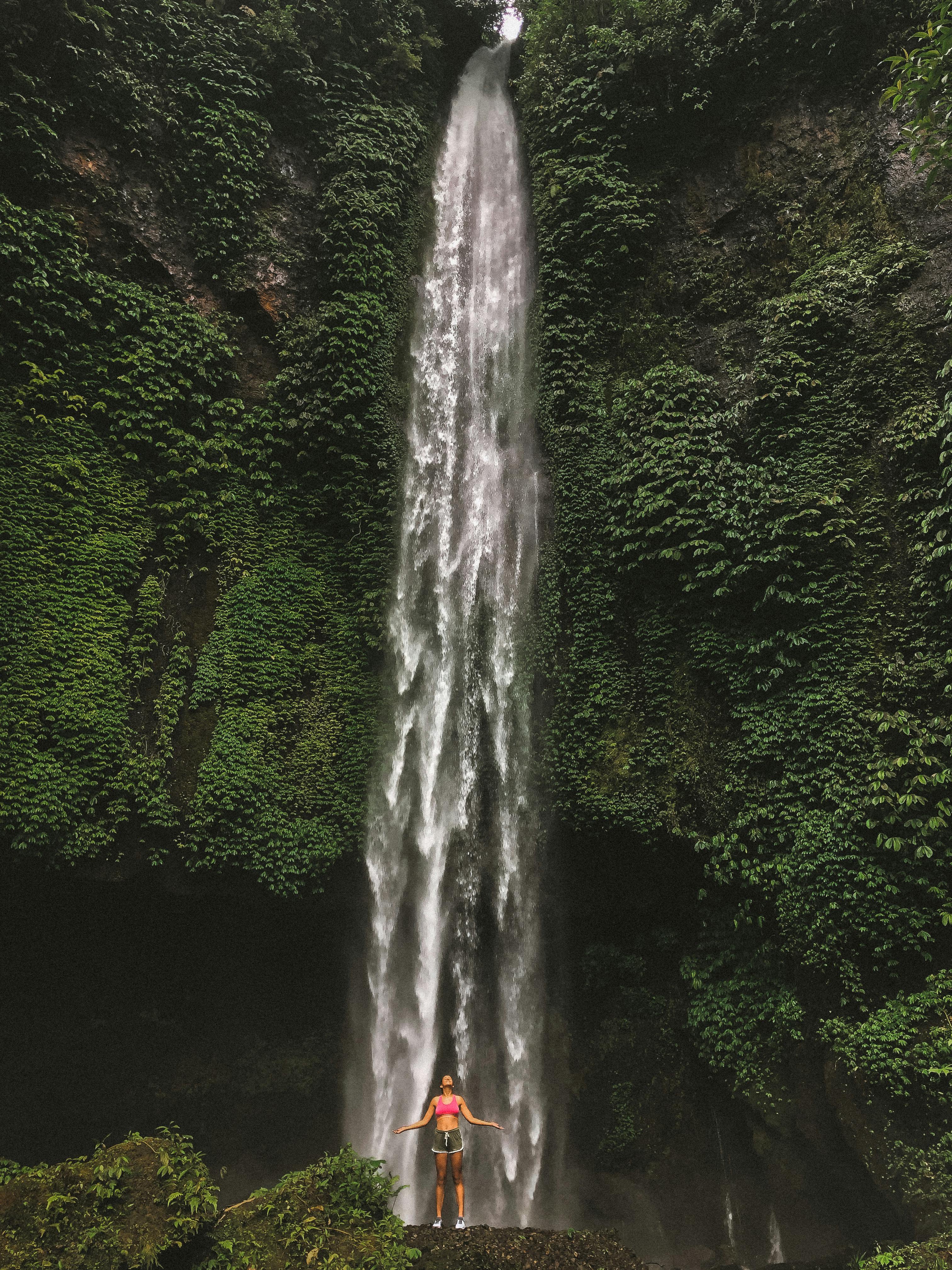 woman standing in front of waterfalls