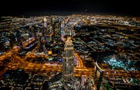 从高角度拍摄的迪拜天际线夜间照明，展现了充满活力的城市景观