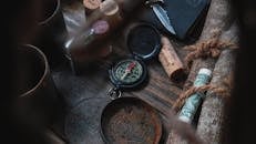 老式旅行物品的布置，包括指南针和软木塞，它们被放置在质朴的木制表面上