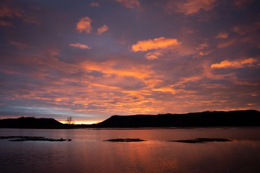 Beautiful sunset with pink clouds reflecting on water in Wabasha, MN.