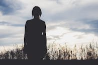 日落时分，一个女人站在科罗拉多斯普林斯的田野里，剪影营造出宁静的场景