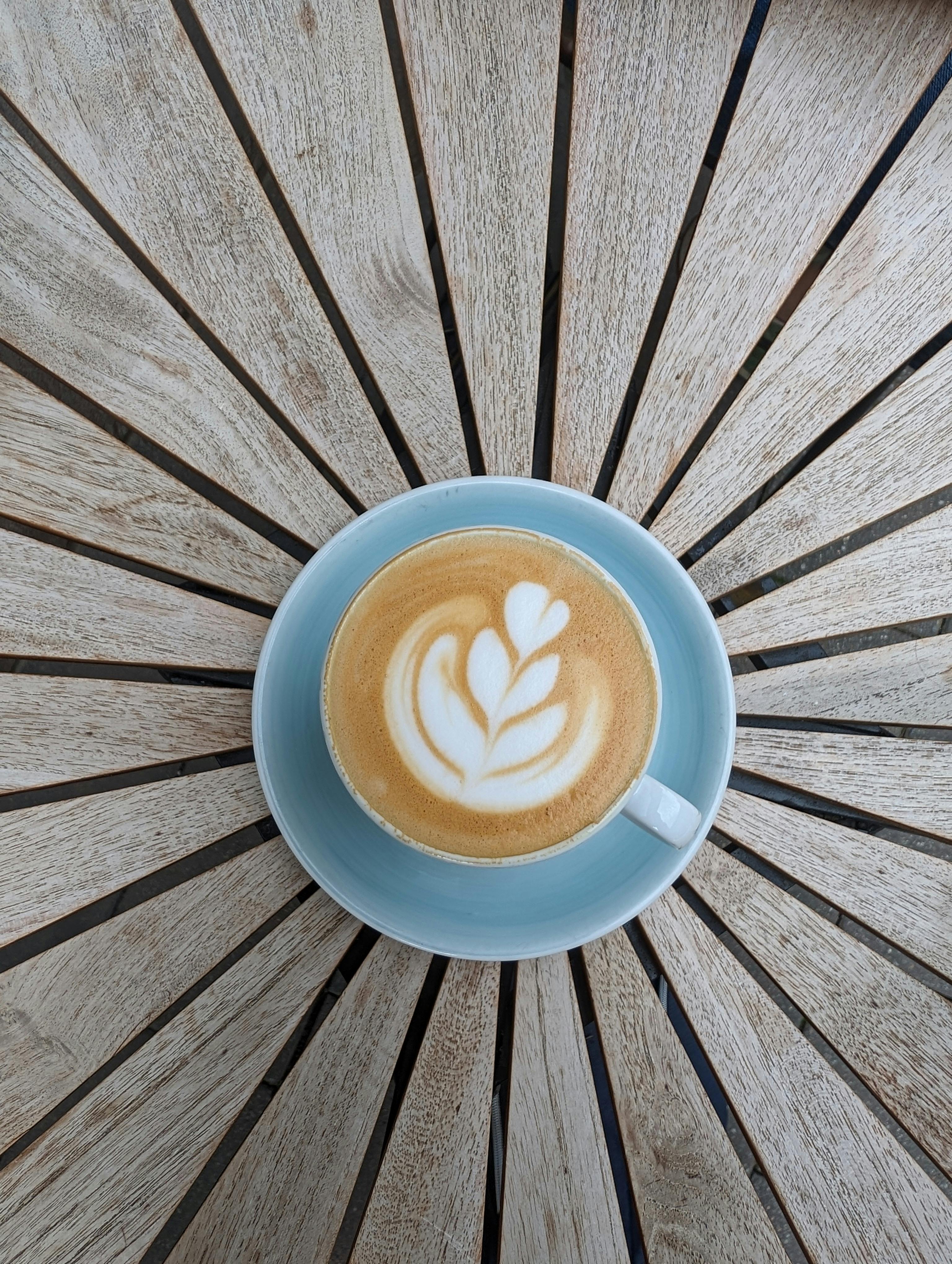 Top view of a latte with beautiful art served on a starburst pattern table in Fürth, Germany.