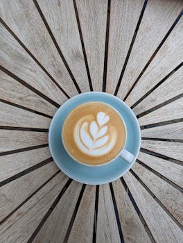 Top view of a latte with beautiful art served on a starburst pattern table in Fürth, Germany.