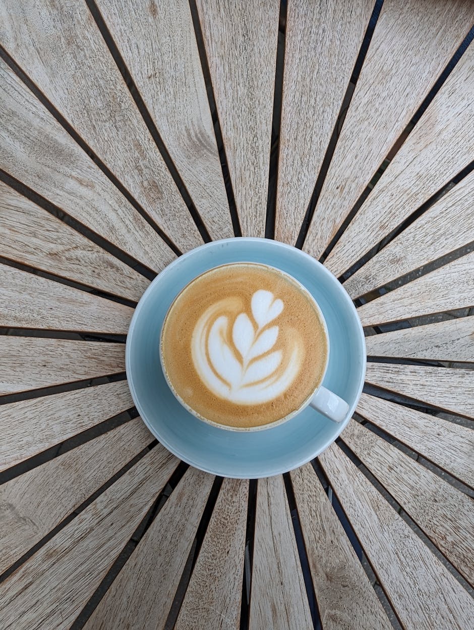 Top view of a latte with beautiful art served on a starburst pattern table in Fürth, Germany.