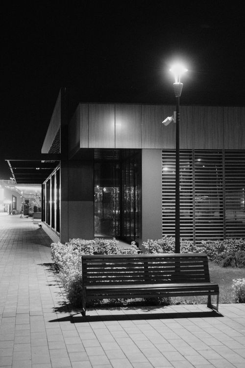 Free Monochrome photo of an illuminated street scene with bench and building in Volgograd. Stock Photo
