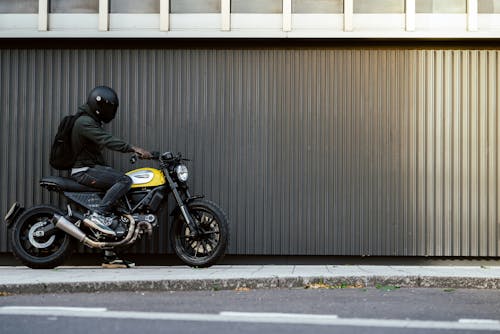 Man in Helmet on Motorbike on Sidewalk