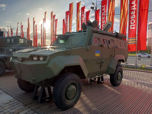 Free An armored military vehicle showcased outside with flags and sunlight in Moscow. Stock Photo