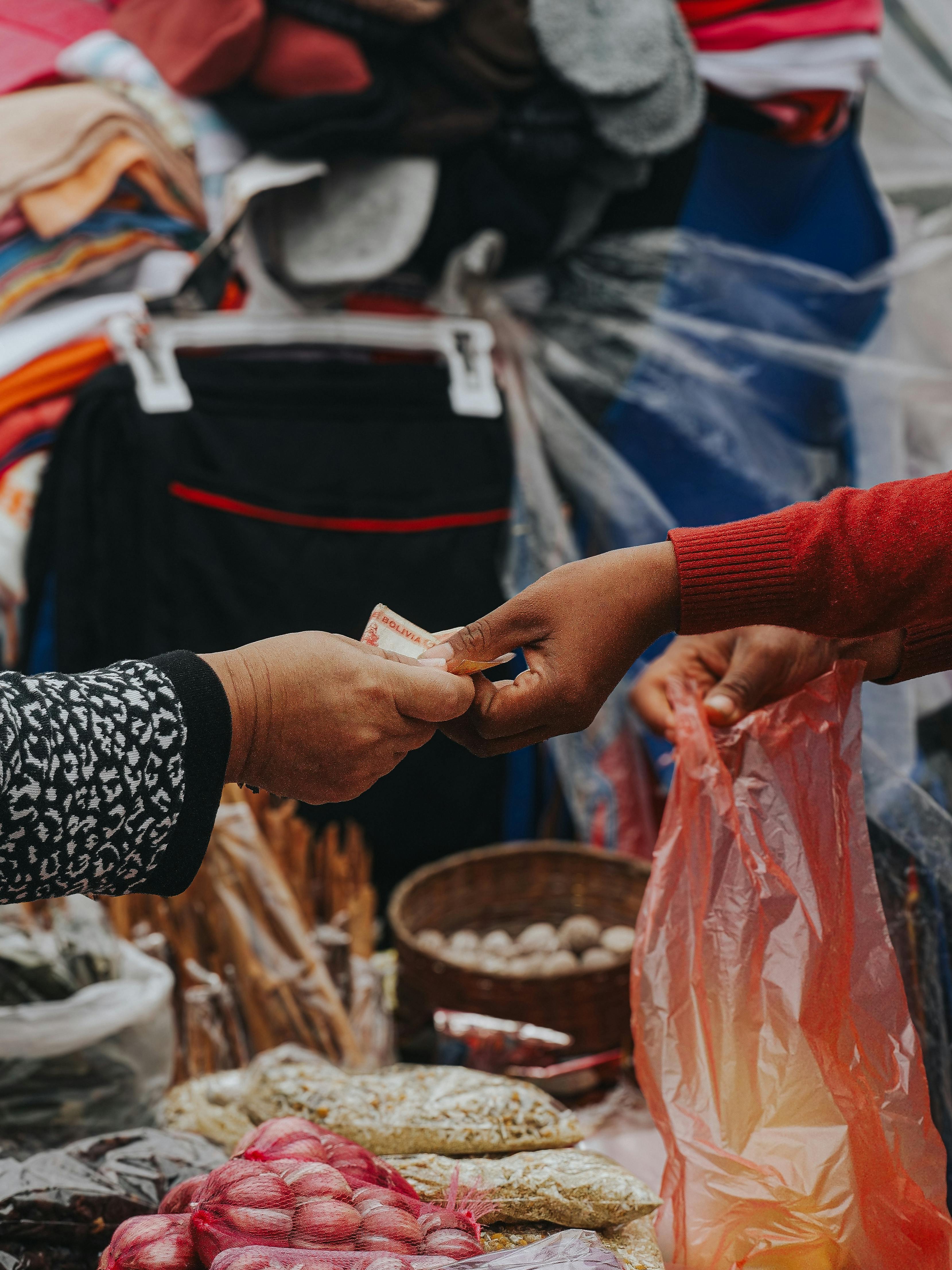 A person handing money to another person at a market