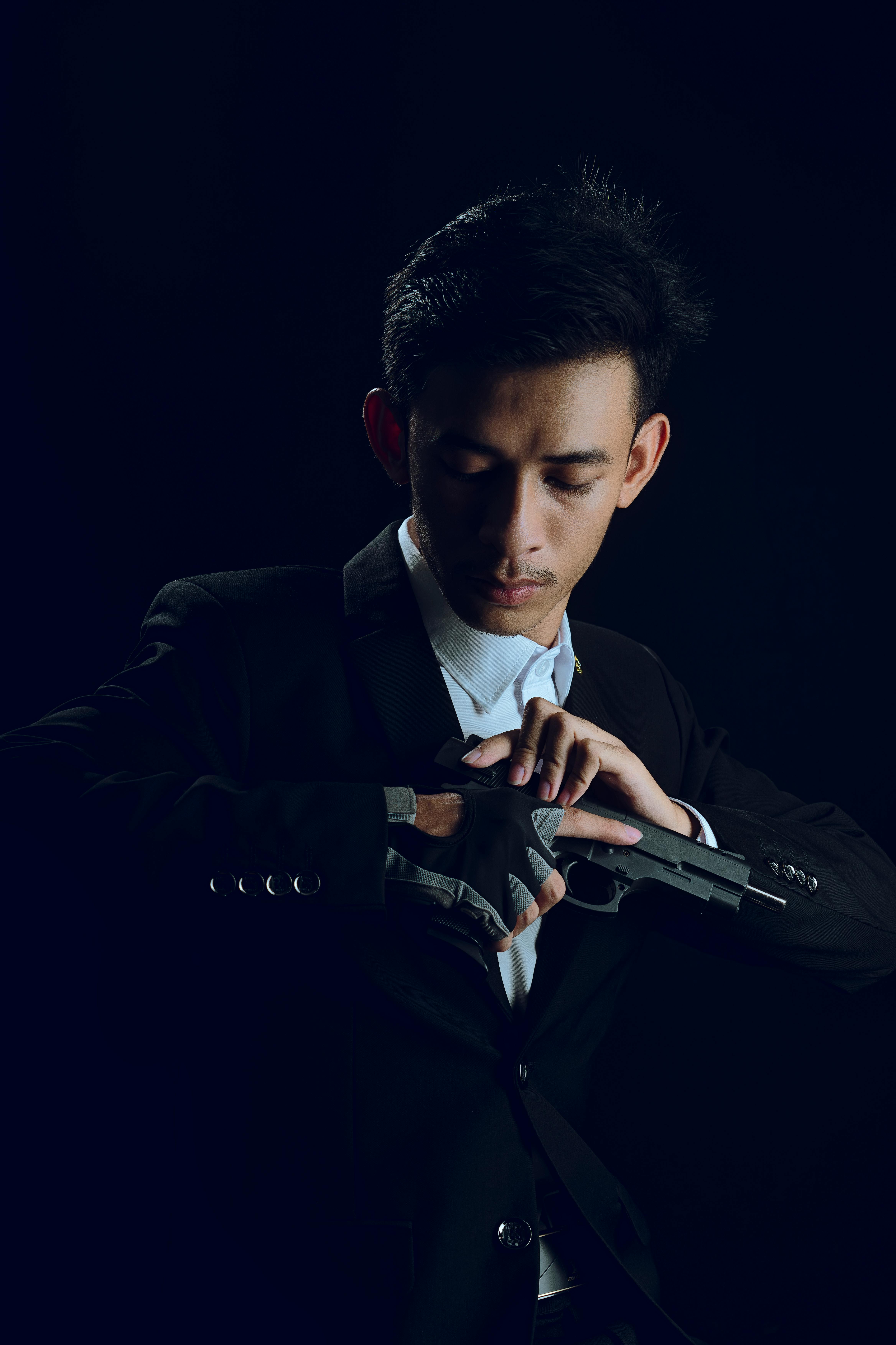 portrait of man in black suit and with pistol