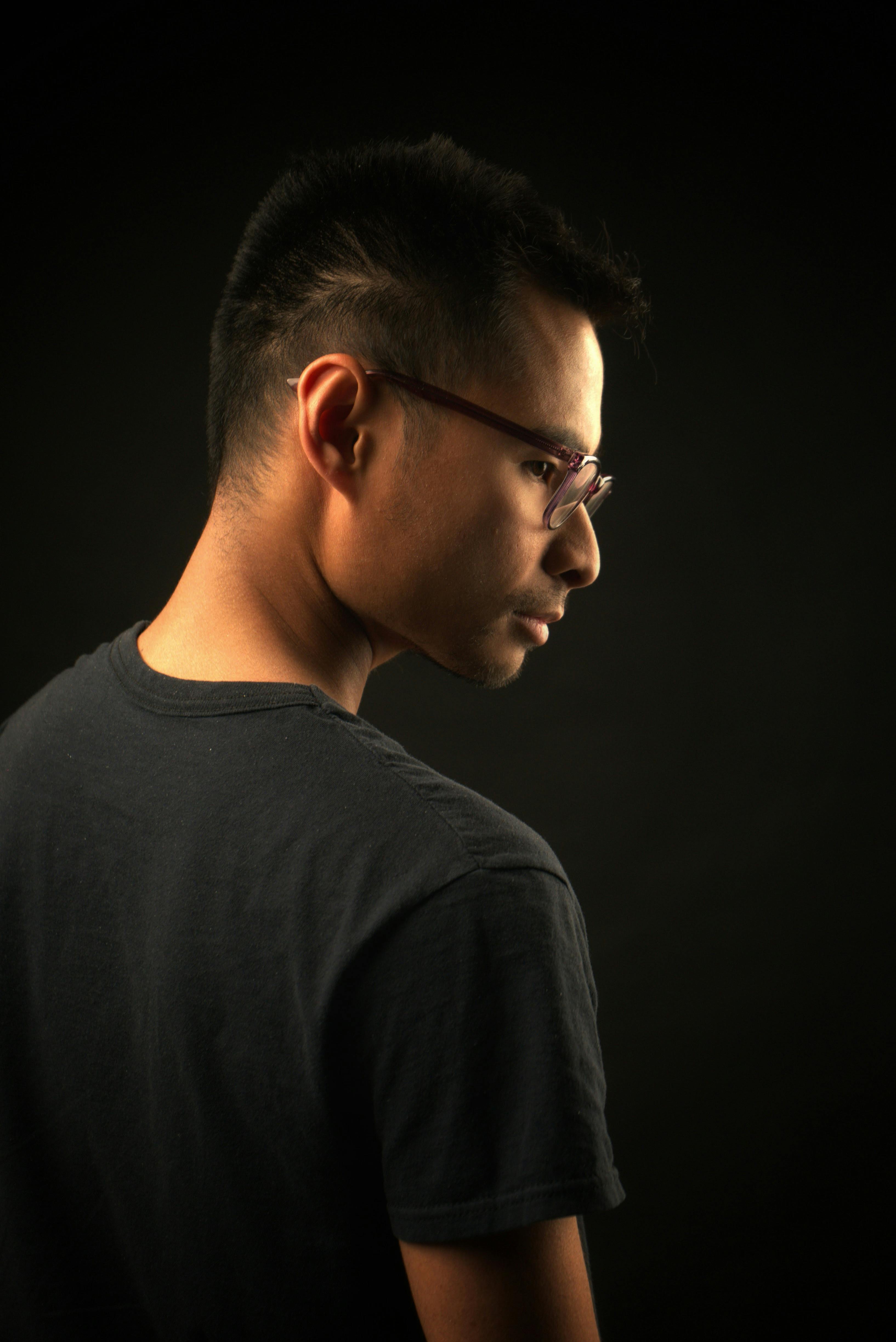 Studio portrait featuring a young man wearing eyeglasses against a dark background in Las Vegas.
