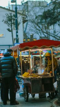 A cozy Istanbul street scene with a vendor selling roasted corn from a colorful cart.