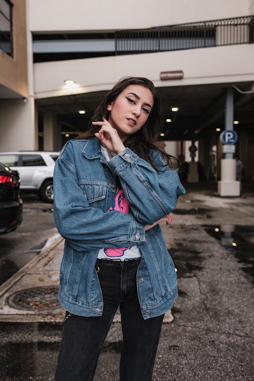 Young Woman in a Casual Outfit with a Jean Jacket Posing on a Street 