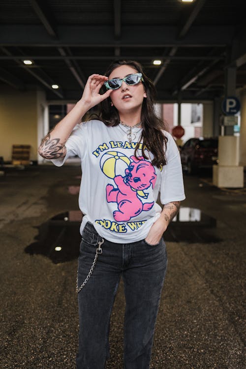 A woman in sunglasses and a t - shirt posing for a photo