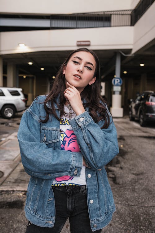 A woman in a denim jacket posing for a photo