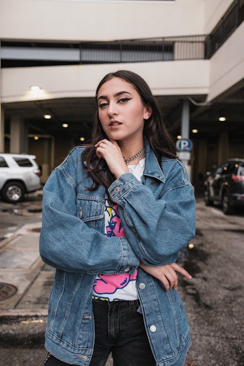 Young Woman in a Casual Outfit with a Jean Jacket Posing on a Street 