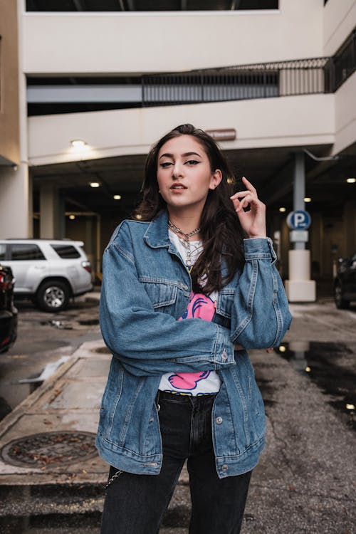 Young Woman in a Casual Outfit with a Jean Jacket Posing on a Street 