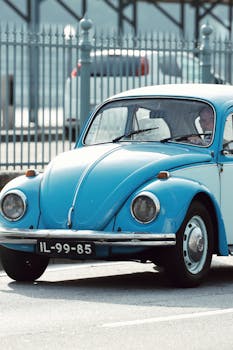 Classic blue Volkswagen Beetle car parked in Porto, Portugal under daylight.