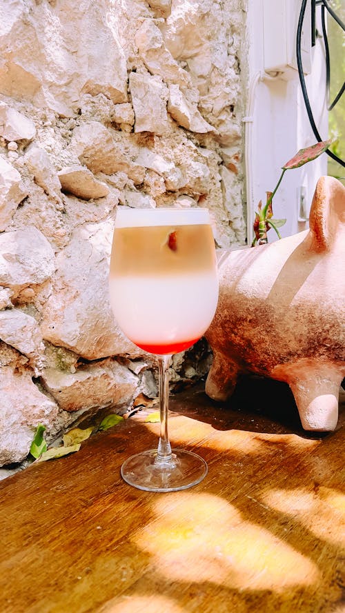 A glass of wine with a pig on the side