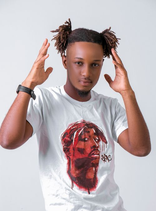 Free Fashionable portrait photo featuring a young black man raising his hands, wearing a white t-shirt, in a studio setting. Stock Photo