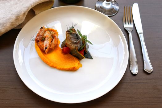 A beautifully plated seafood dish with shrimp and fish on an elegant plate, captured in Oporto.