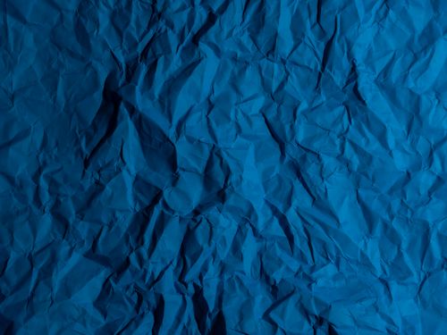 Free Close-up of a blue wrinkled paper texture, ideal for backgrounds and design use. Stock Photo