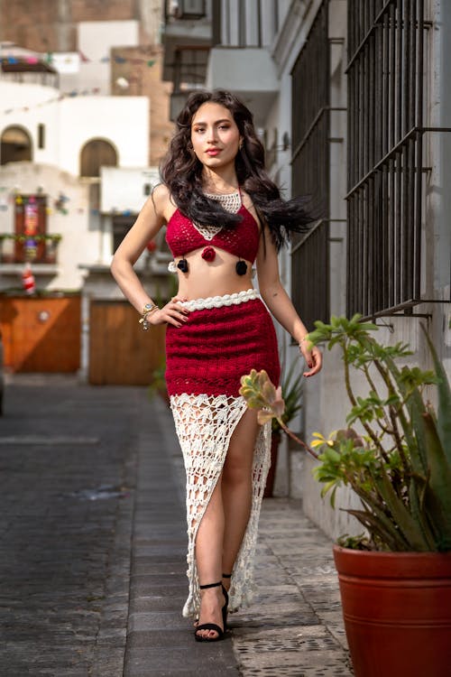 Young Woman in a Crochet Top and Skirt Posing on a Sidewalk 