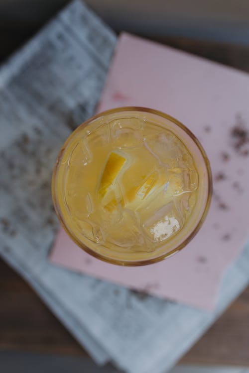 A glass of orange juice with a slice of lemon on top