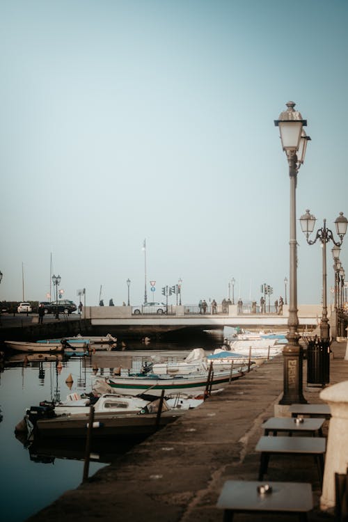 A pier with boats and lights on it