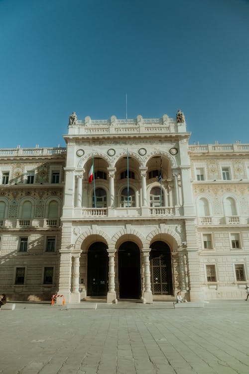 A large building with a clock tower and flags