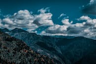 令人惊叹的山区景观与戏剧性的云，唤起了冒险与宁静之感