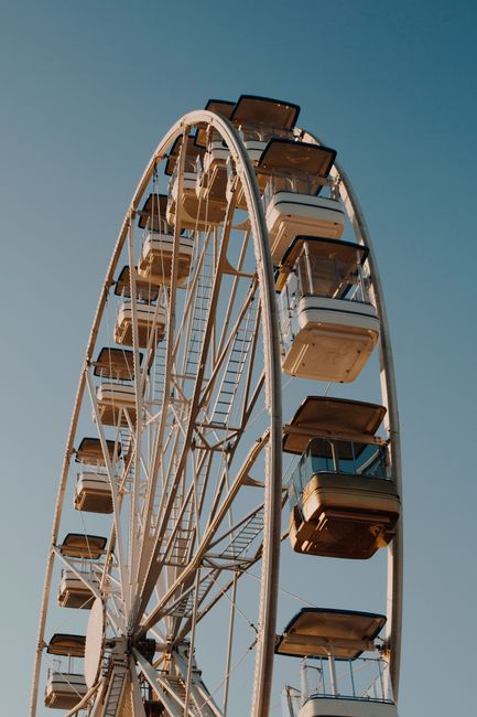 Experience the thrill of a Ferris wheel on a clear day in Lisbon's amusement park.