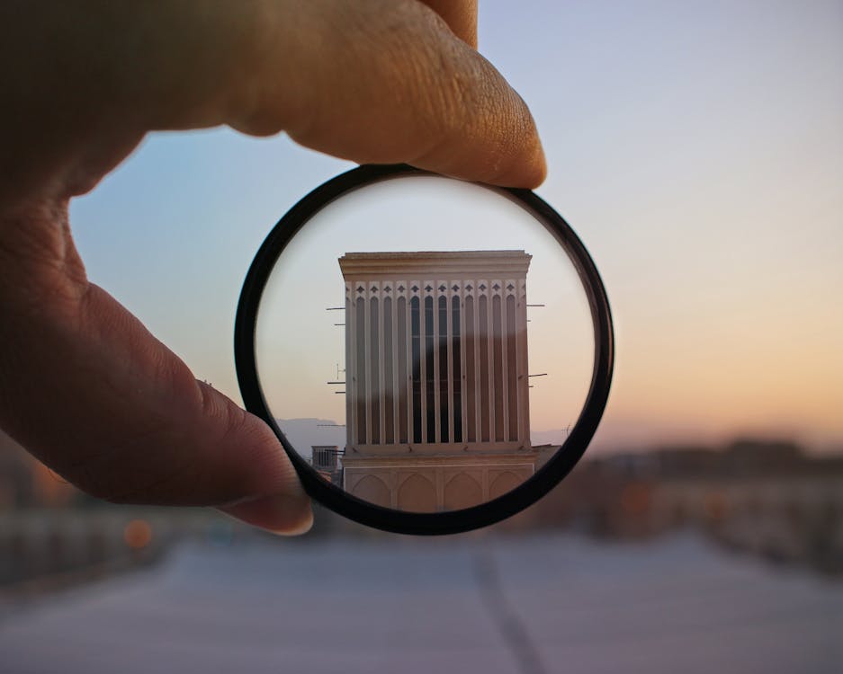 Person Holding Magnifying Glass Showing Building