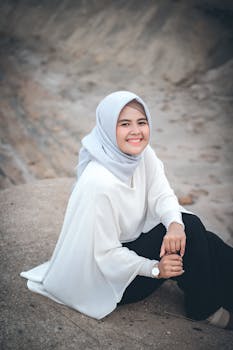 一位面带微笑、头戴灰色头巾的女性户外肖像，散发着温暖与优雅