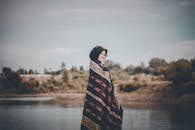 一位快乐的女子在宁静的湖边摆着姿势，享受户外时光