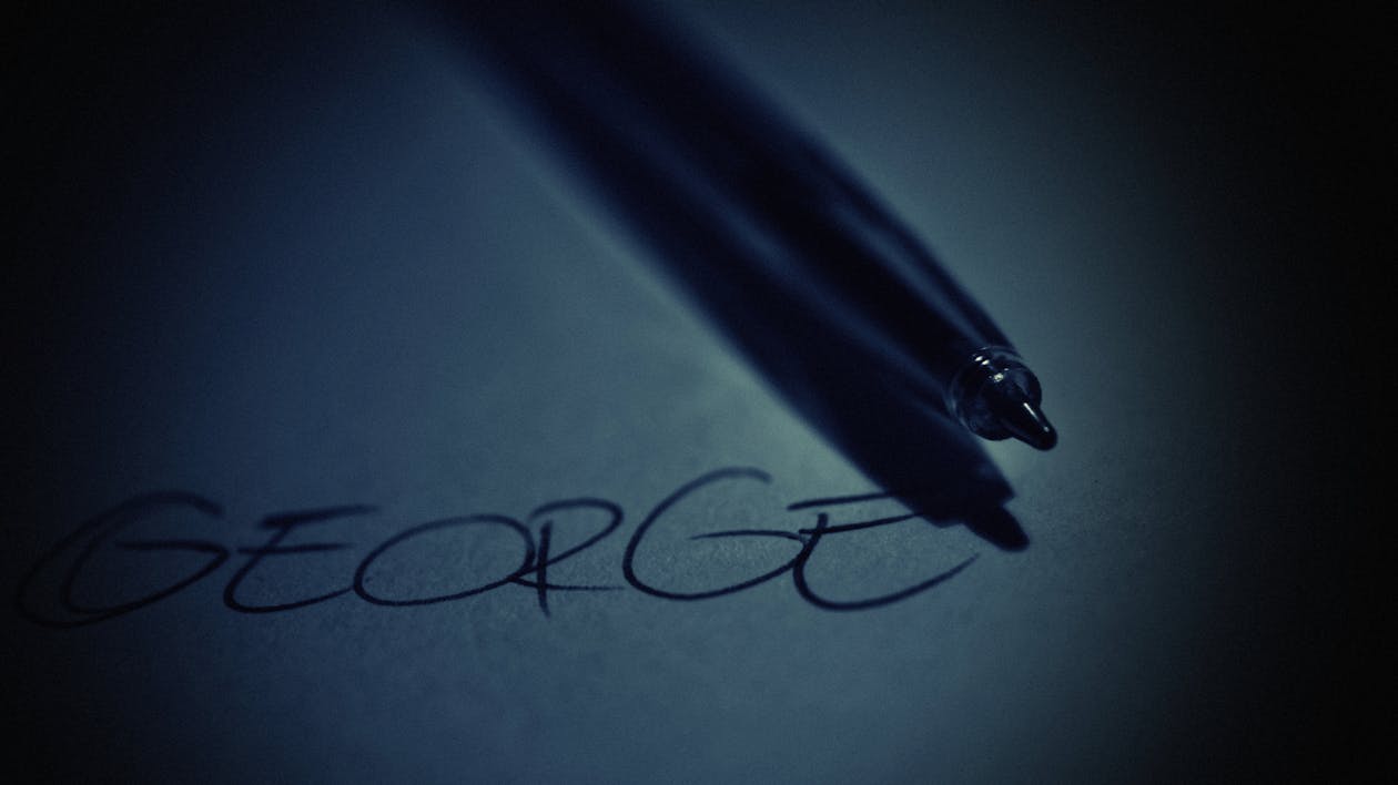 Free Black Pen on Top of White Paper With George Text Stock Photo