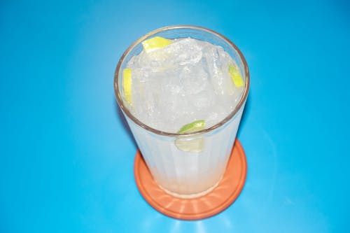 A glass of lemonade with lime wedges on top