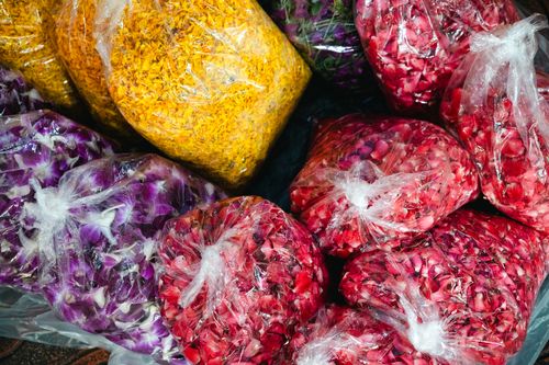 Free Vibrant packs of colorful flower petals wrapped in plastic bags, ready for sale. Stock Photo