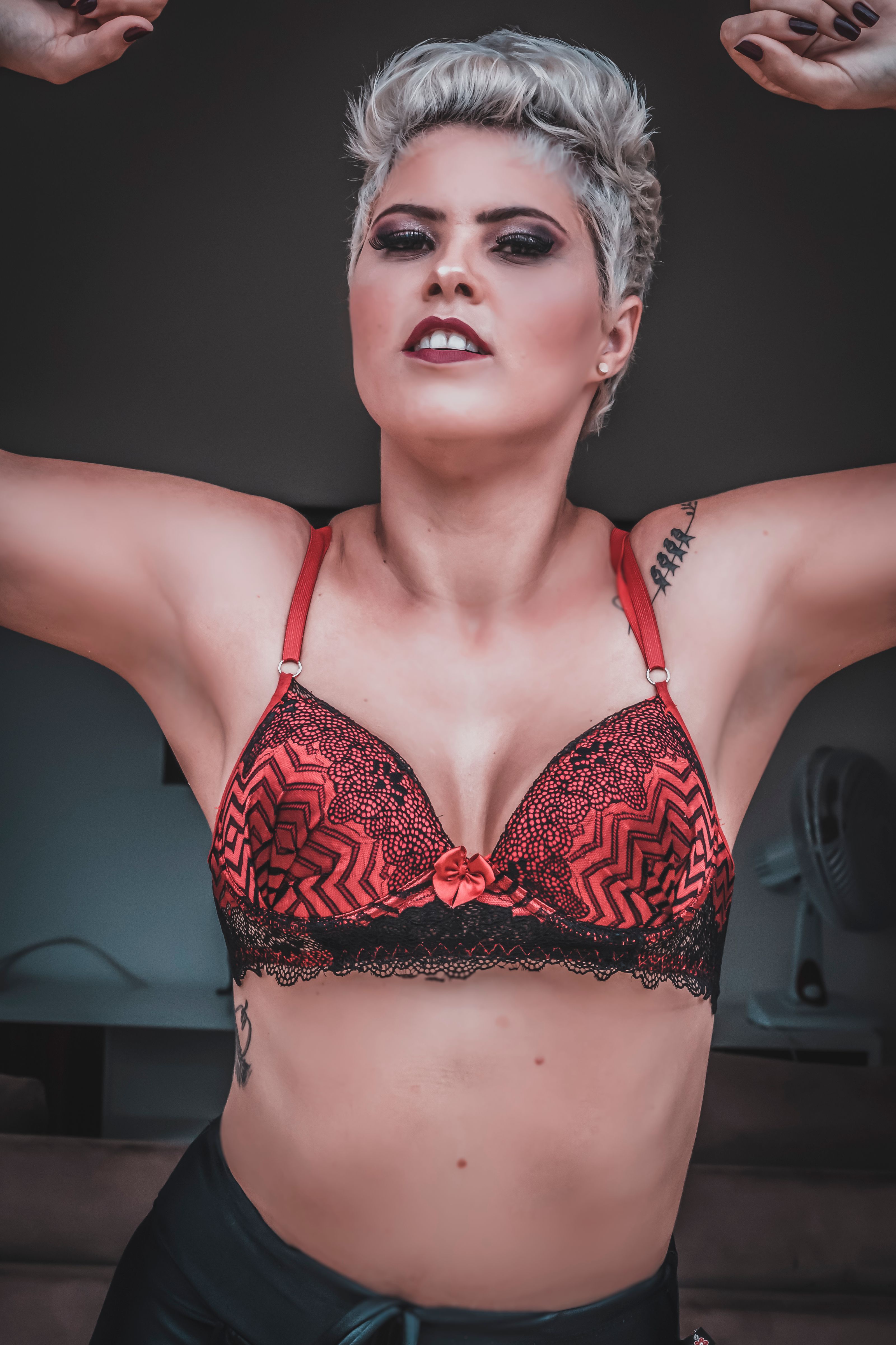 Imagem poderosa de uma mulher confiante em um sutiã vermelho e preto ousado, expressando empoderamento.