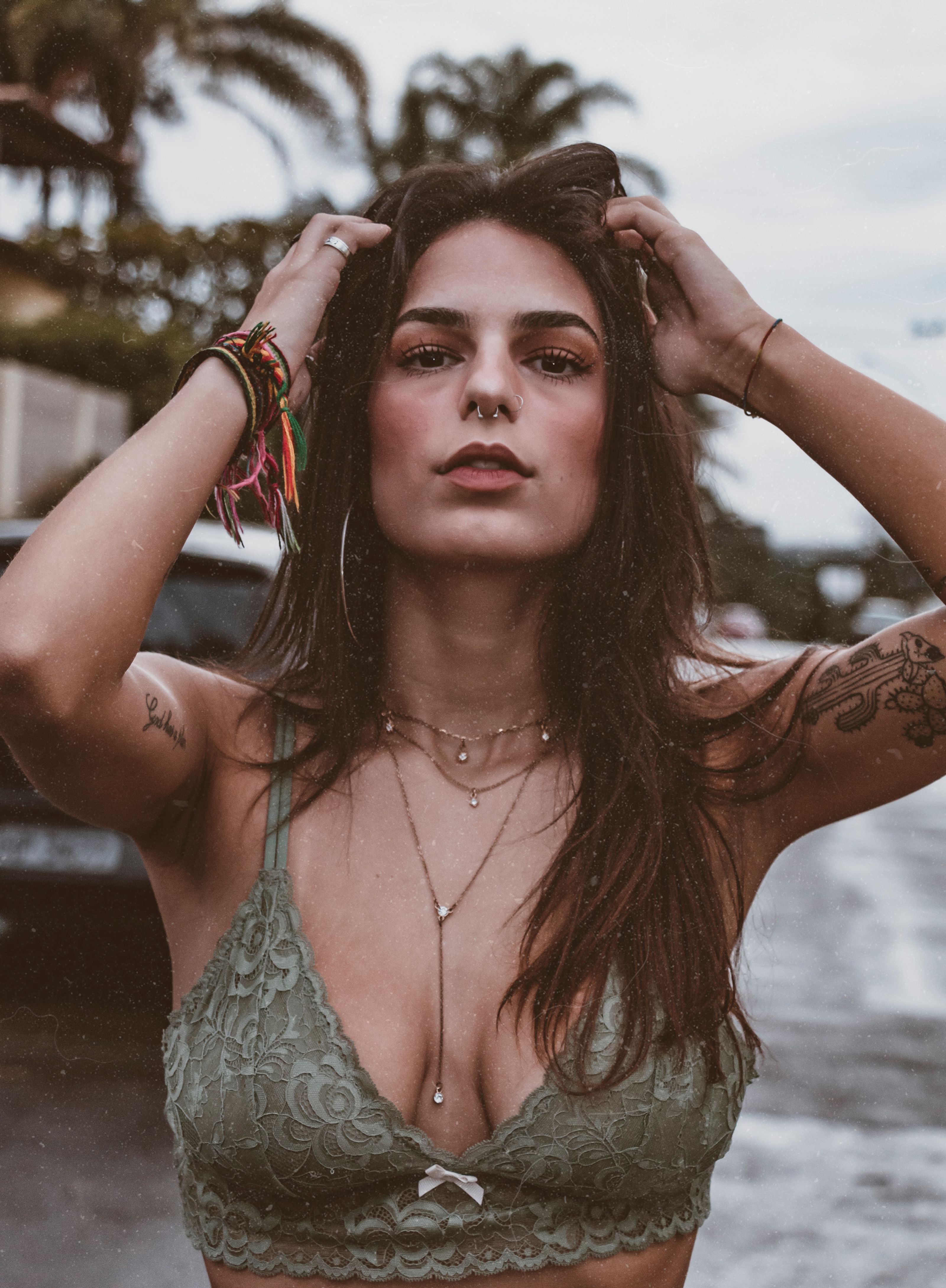 Retrato de uma mulher tatuada posando ao ar livre no Brasil, exibindo moda de verão.