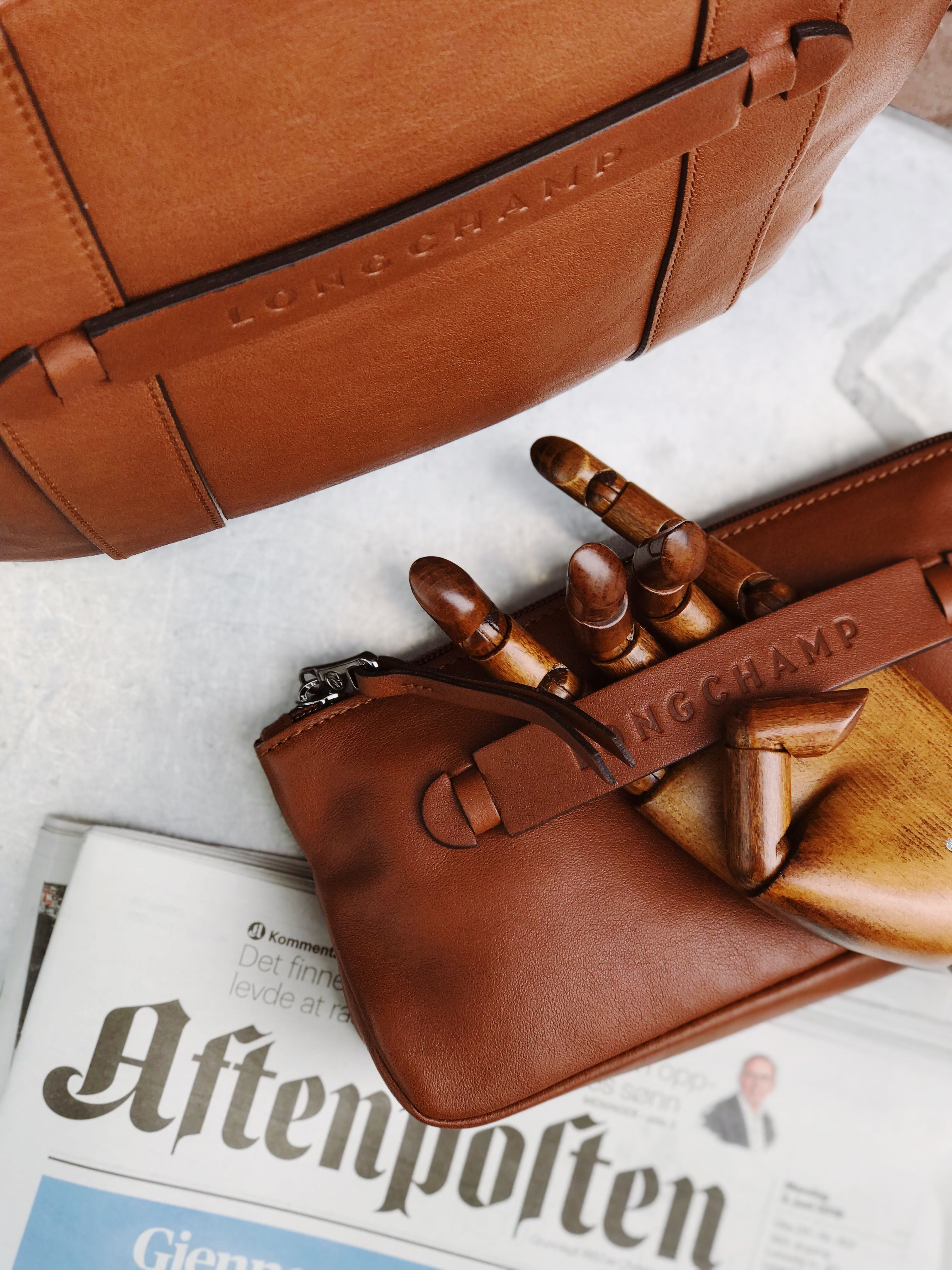 A brown leather handbag product shot highlighting stitching and hardware for a handbag tech pack