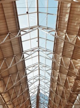 Low angle shot of a contemporary steel and glass ceiling structure, showcasing modern architectural design.