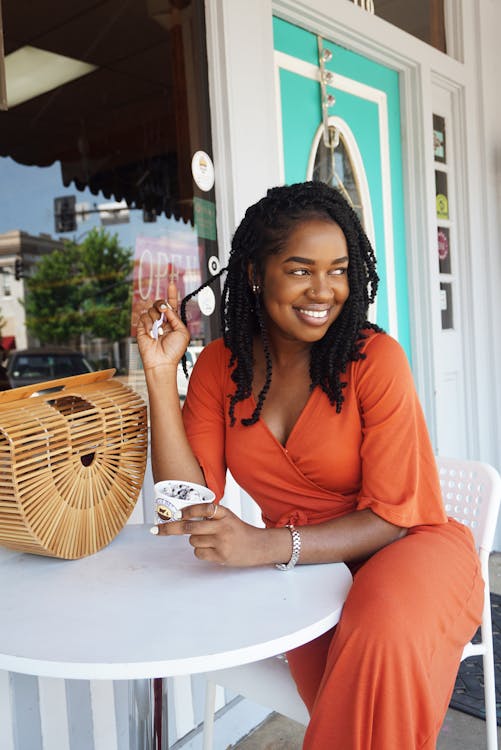 Free Woman Wearing Orange V-neck Overall Dress Sitting on Chair Stock Photo