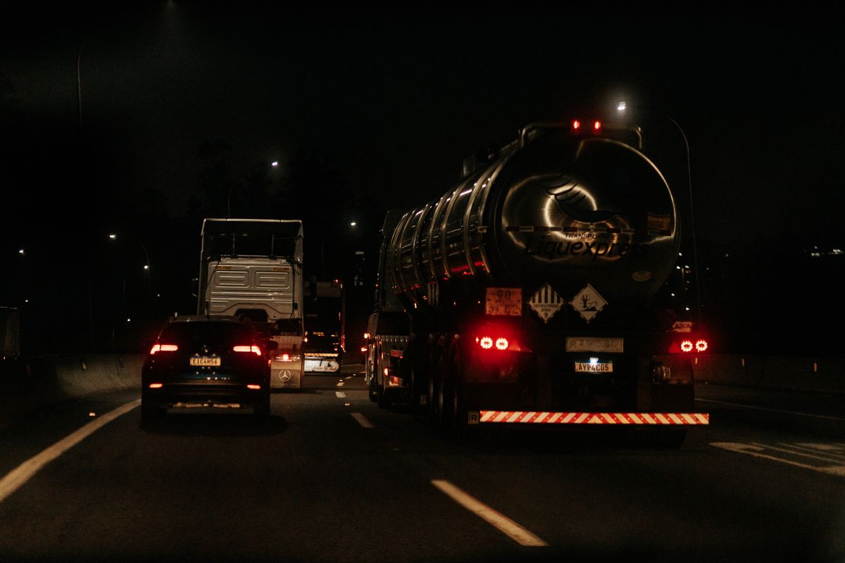 夜の高速道路を走るトラックのテールランプ