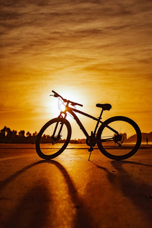A bicycle is silhouetted against the sunset