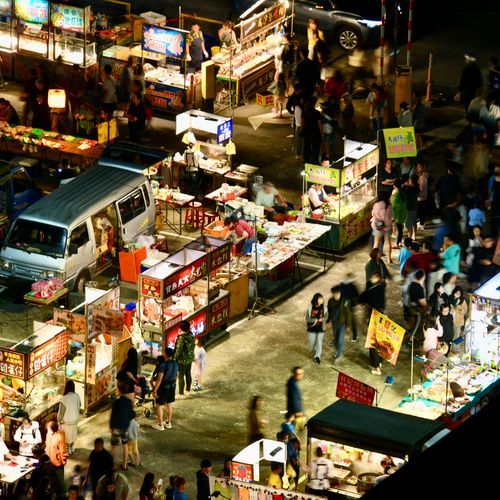 Free High-angle view of a bustling night market filled with colorful food stalls and lively crowds. Stock Photo