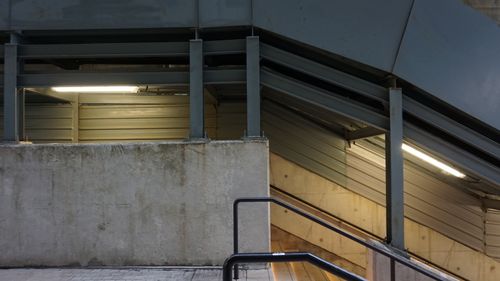 Free A geometric and abstract view of an industrial metal staircase lit by overhead lights. Stock Photo