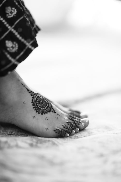 Black and white photo of a woman's feet with henna
