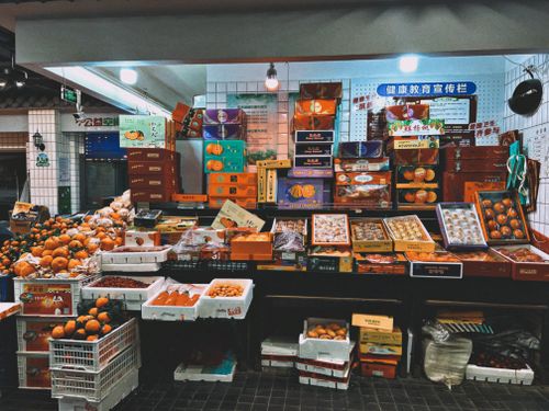 Free Colorful display of fresh fruits and packaged produce at an indoor Shanghai market. Stock Photo