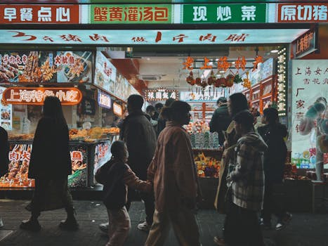 Lively street scene at a night market in Xangai, China, showcasing vibrant local culture and cuisine.